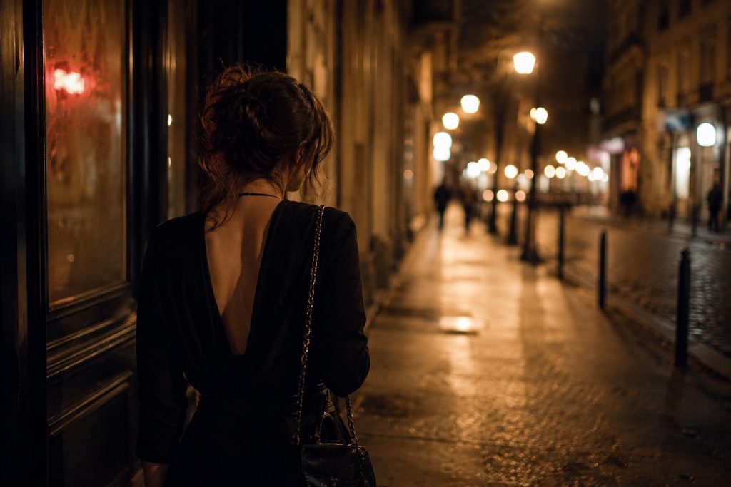 Femme seule dans une rue nocturne après une soirée libertine, ambiance introspective et calme